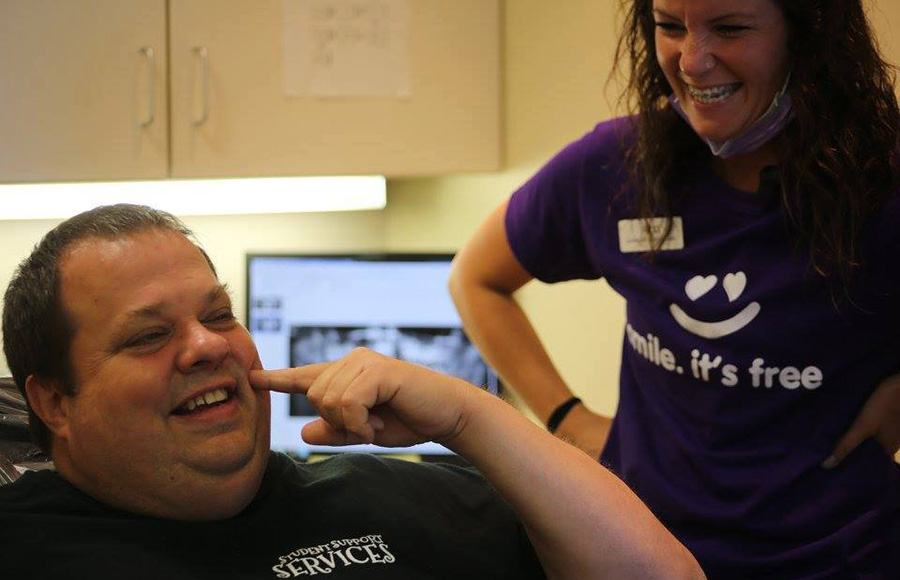 Smiling dental team member and patient pointing to cheek