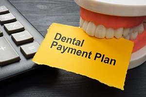 Artificial teeth biting paper that says dental payment plan
