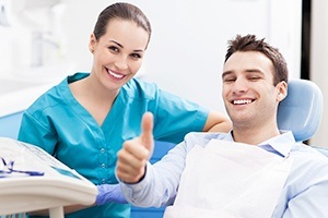 Man in dental chair giving thumbs up