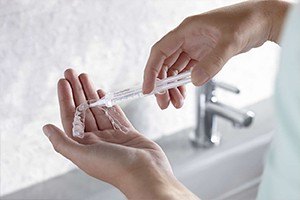 Patient placing whitening gel in application tray