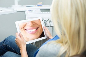 Woman looking at smile design on tablet computer