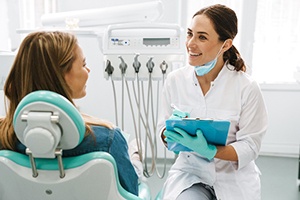 Smiling cosmetic dentist asking patient questions at consultation