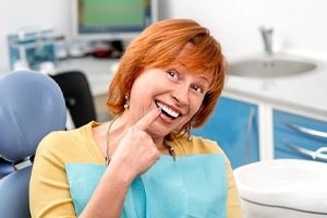 A woman pointing to her smile