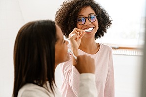two sibling brushing their teeth together