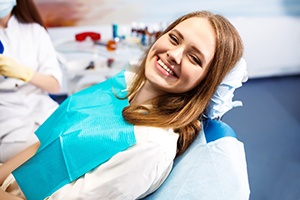 A young female lying back in the dentist’s chair and smiling after receiving a tooth-colored filling in Springfield