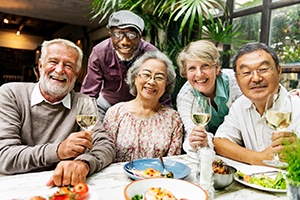 Older dental implants patient in Springfield smiling with friends