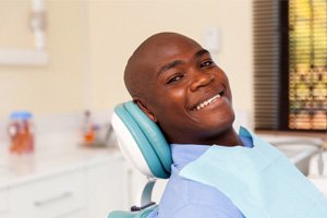 Reclining man smiling after getting dental implants in Springfield 