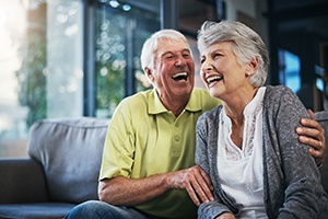 Older couple laughing and smiling after using their dental insurance in Springfield
