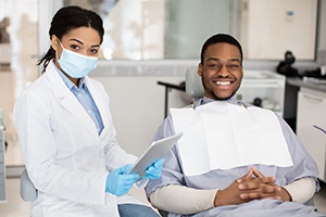 Dentist and male patient smiling