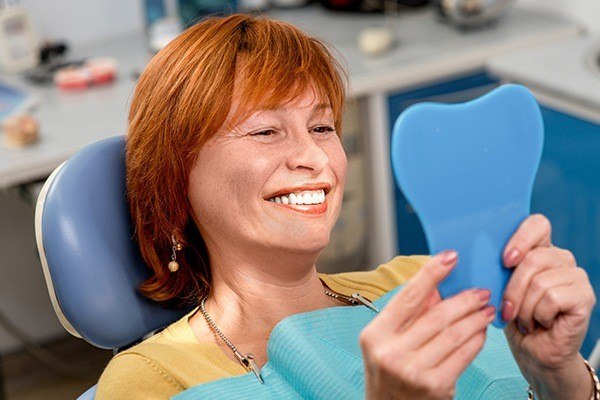 woman in dental chair looking in a mirror