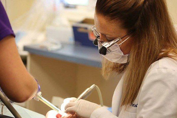 dentist cleaning patients teeth