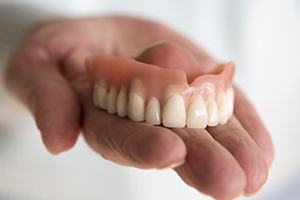 Hand holding full denture