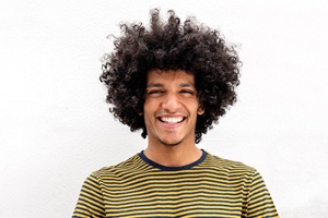 person smiling and standing outside