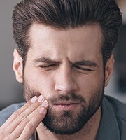 Man holding jaw in pain