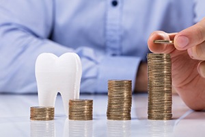 Coins being stacked next to a tooth