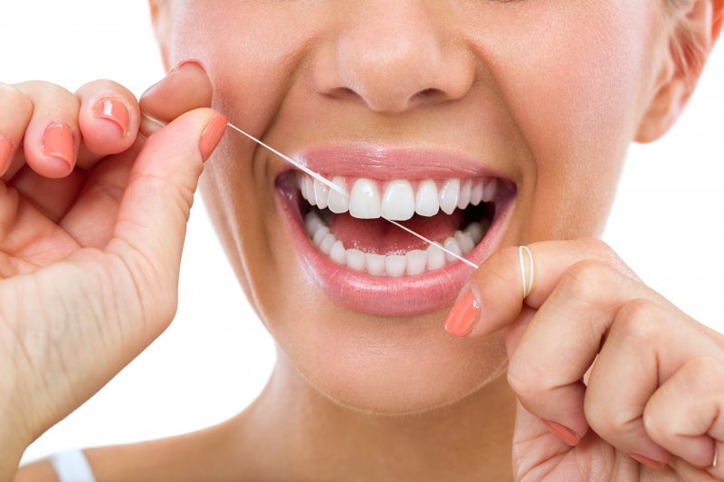 Smiling woman flossing 