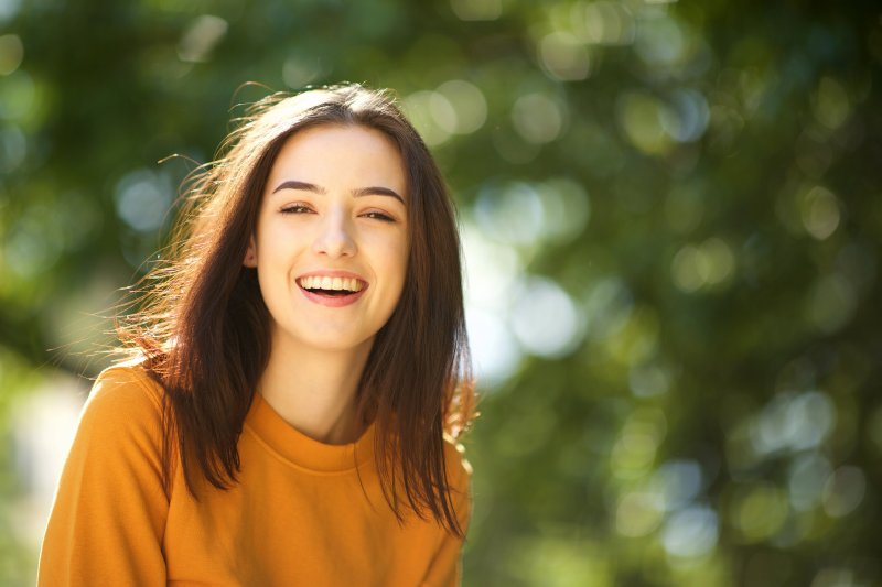 close up of woman smiling in park