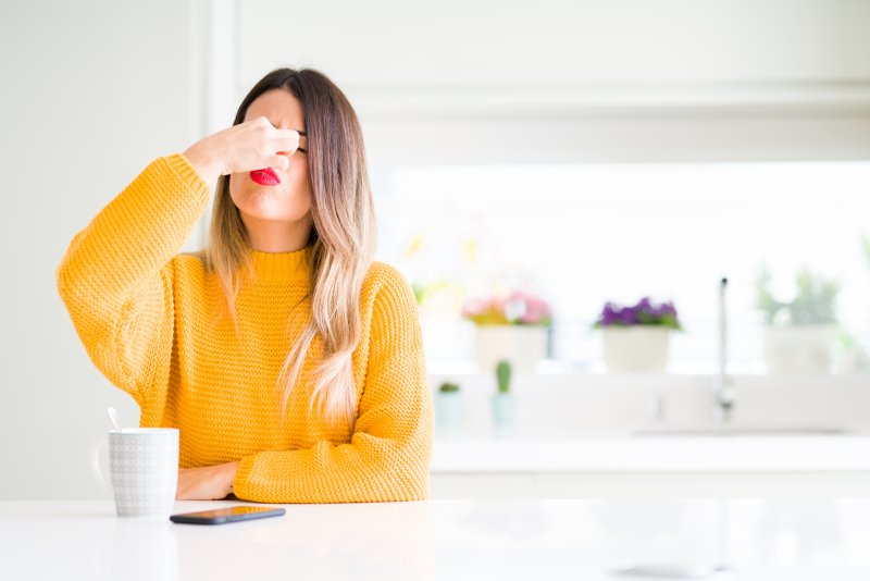 woman pinching nose from coffee breath in Springfield