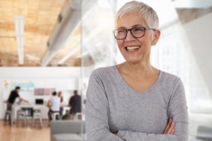 smiling woman who received dental implants after menopause 