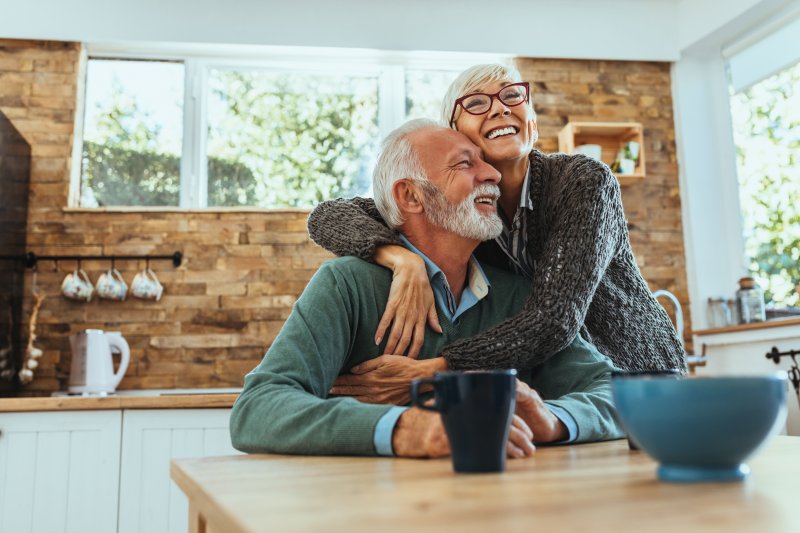 An older couple with dentures embracing