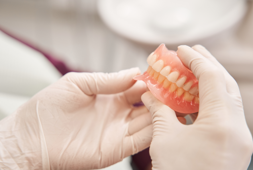 Hands holding dentures