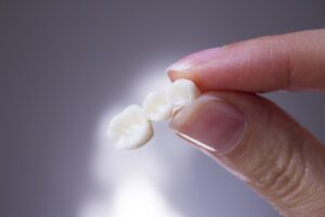 Person holding a dental bridge